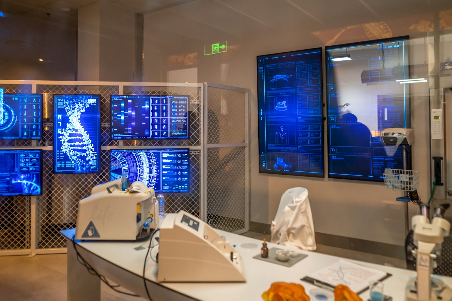 Pantallas digitales muestran hélice de ADN y datos genéticos en un laboratorio moderno.