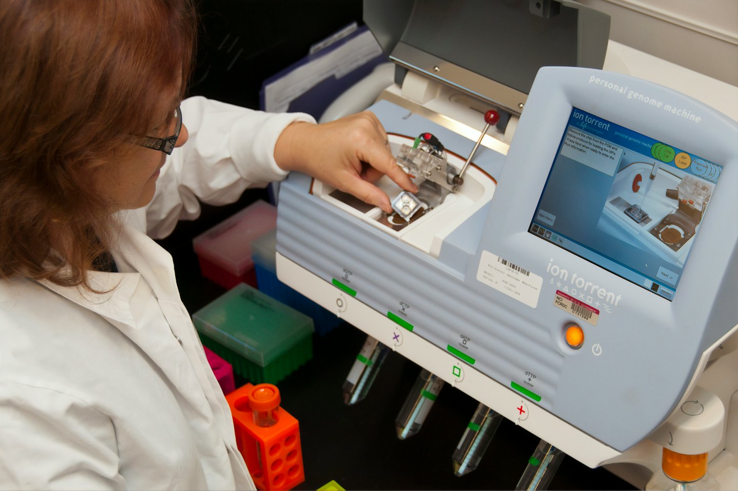 Científico coloca un componente en una máquina de genoma personal.